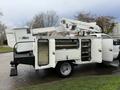 A 2008 Ford F-550 utility truck with an Altec aerial lift on the back featuring open storage compartments and a hydraulic lifting arm
