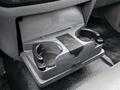 A gray cup holder with two circular slots for beverages and a small sliding cover in the center