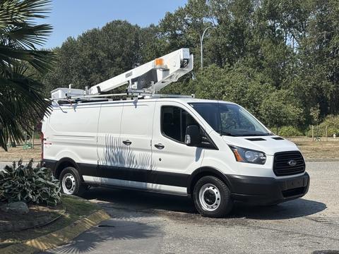 A white 2019 Ford Transit 350 van with a ladder rack mounted on top is parked on a paved area