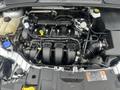 Engine compartment of a 2018 Ford Focus featuring the engine block with intake manifold hoses and various components visible
