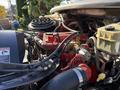 Close-up of the engine components of a 2012 Freightliner M2 106 showing various pipes wires and a red engine block