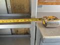 A measuring tape laid across a metal surface with markings visible up to 36 inches
