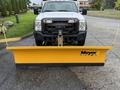 A white 2013 Ford F-450 SD truck equipped with a yellow Meyer snow plow attached to the front