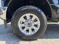 Close-up of a chrome wheel with a silver multi-spoke rim and a large all-terrain tire showcasing a rugged tread design
