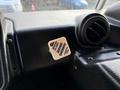 A square, white parking brake release button with black text reading "To Pull Parking Brake Release" attached to a textured black surface