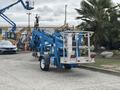 A blue 2016 Genie TZ-34/20 boom lift positioned with its extendable arm retracted and parked on a concrete surface