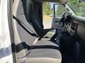 Interior view of a 2019 GMC Savana with two front seats and a dashboard visible highlighting the spacious design and fabric upholstery