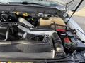 An open engine compartment of a 2015 Ford F-550 showing various components including hoses battery and coolant reservoir