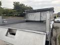 A rear view of a 2014 Ford F-550 with a flatbed truck design featuring a smooth black surface and metal sides