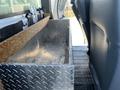 A metal storage box with a wooden top is mounted between the front seats of a vehicle