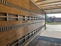 A 2012 Hino 338 truck with an empty cargo area featuring wooden walls and metal rail tracks along the sides for securing loads
