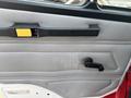 The image shows the interior door panel of a 1999 Freightliner FL80 featuring a handle and a circular window cranking mechanism
