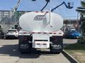 A 2014 Freightliner M2 106 truck with a white tank body and red and white striping on the sides parked in a lot