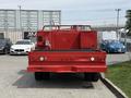 Red 2013 Ford F-550 truck viewed from the rear with a flatbed and mounted equipment including a water tank and fire extinguisher