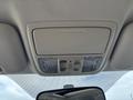Overhead console of a 2014 Honda CR-V featuring two buttons for interior lights and a small mirror reflecting part of the dashboard