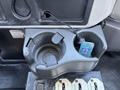 A cup holder with a remote control resting inside it mounted on a dashboard of a 2008 International DuraStar truck