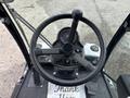 A top view of the steering wheel and control panel of a 2019 Madvac LS175 featuring various buttons and a speedometer