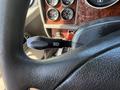 Close-up of the control lever on the steering column of a 2009 Kenworth T270 showing the headlight indicator and the textured grip of the steering wheel