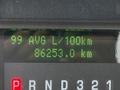 A digital display showing average fuel consumption of 99 liters per 100 kilometers and total distance traveled of 86253 kilometers on a vehicle dashboard