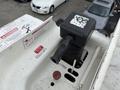 A control handle on a Freightliner M2 106 featuring warning labels and a red button on a white surface