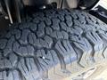 Close-up of a rugged tire tread from a 2021 Jeep Wrangler showcasing deep grooves designed for off-road traction and stability