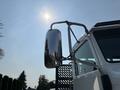 A 2020 Peterbilt 330 truck with a shiny side mirror reflecting light from the sun