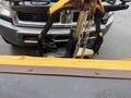 A 2011 Dodge Ram 5500 with a snow plow attachment on the front connected by a chain and metal brackets
