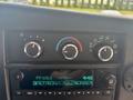 Dashboard control panel of a 2020 Chevrolet Express featuring knobs for temperature and airflow alongside a digital display for radio tuning