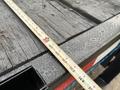 A 2008 Sterling Bullet trailer with a measuring tape laid across its wooden surface displaying raindrops on the wood