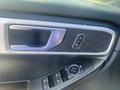 Close-up of the driver's side door panel of a 2020 Ford Explorer featuring controls for locks and mirrors as well as a textured speaker grille