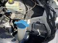 A 2010 Mercedes-Benz Sprinter engine compartment featuring various components including a fluid reservoir and an electronic control module