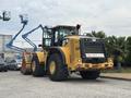 A 2012 Caterpillar 980 wheel loader with large tires is stationary showcasing its yellow and black exterior with a bucket attachment at the front