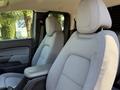 Interior of a 2018 GMC Canyon showing two grey fabric front seats with adjustable headrests and a central armrest
