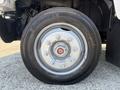 Close-up of a wheel and tire on a 2005 GMC C7500 Topkick showing the rim and lug nuts with tread pattern visible on the tire