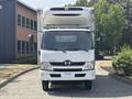 Front view of a 2018 Hino 195 truck featuring a large cargo box and a prominent grille with the Hino logo