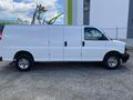 A side view of a white 2023 GMC Savana cargo van with a smooth exterior and large wheels