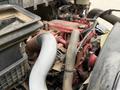 Close-up view of the engine of a 2020 International MV607 featuring red components and various hoses and pipes connected to it