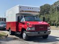 A red 2007 GMC C4500 TopKick vehicle with a white boxy cargo area and multiple lights on the roof