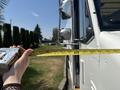 A 2012 Ford Econoline van with a measuring tape extended from a person's hand to the vehicle's door
