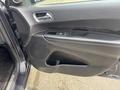 The interior door panel of a 2015 Dodge Durango featuring a speaker an armrest and controls for windows and locks