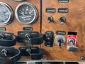 Control panel of a 2008 Peterbilt 340 featuring gauges for oil temperature and transmission, various switches, and levers for locking and unlocking functions