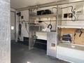 A 2008 Wells Industries Inc EW1422 features stainless steel countertops and compartments with plumbing connections and various electrical equipment mounted on the walls