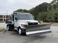 A 2012 International TerraStar truck equipped with a snow plow attached to the front and two safety flags positioned upright