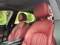 Red leather seats of a 2016 Maserati Ghibli with headrests featuring the Maserati logo visible in the foreground