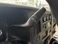 Close-up of the gearshift lever on a 2020 Chevrolet Express showing a black handle with plus and minus buttons for gear shifting