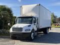 A white 2012 Freightliner M2 106 box truck with a large cargo area and side mirrors parked on a driveway