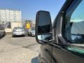 2016 Ford Transit 150 front side mirror with a partial view of the van's body and nearby parked cars in the background