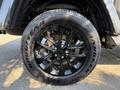 A close-up view of a black wheel and tire from a 2021 Jeep Gladiator featuring a distinctive wheel design and Goodyear Wrangler tire tread