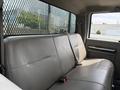 Interior of a 2008 Ford F-550 with a gray bench seat and a safety strap in the foreground