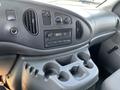 Dashboard of a 2005 Ford Econoline with radio controls and cup holders displayed